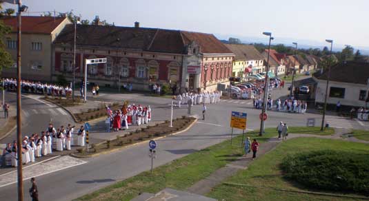 U SVECANOM MIMOHODU IZ SVIH OKUCANSKIH ULICA SE SLIJEVAJU POVORKE  FOLKLORNIH SKUPINA I KUD-ova U SREDIŠTE TOG SLAVONSKOG MJESTA 